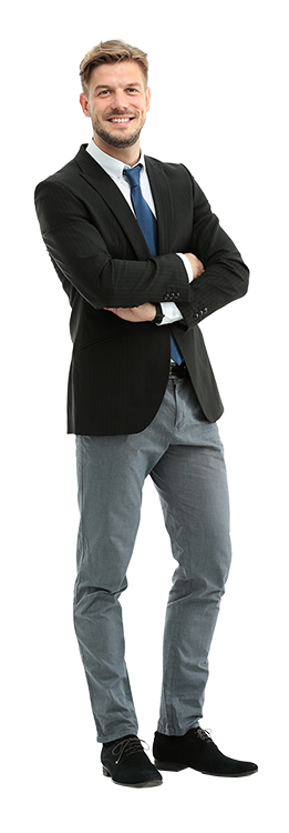 Ein junger Mann mit schwarzem Blazer, blauer Krawatte, weißem Hemd und grauer Hose steht lächelnd mit verschränkten Armen vor seinem Industriefachwirt IHK Kurs. Er hat kurze Haare und trägt schwarze Schuhe. IFF Akademie - kaufmännische Weiterbildung
